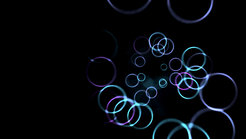 Various sizes of glowing circles float in front of a dark background.